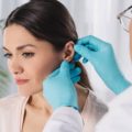 Mulher sendo examinada pelo médico após uma cirurgia estética na orelha