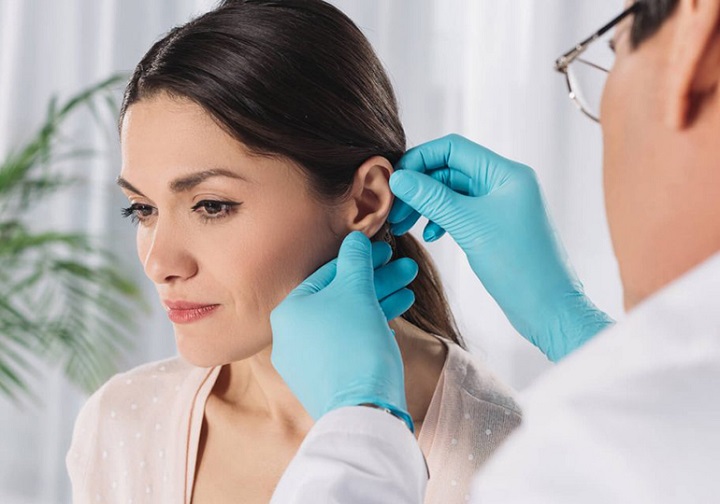 Mulher sendo examinada pelo médico após uma cirurgia estética na orelha