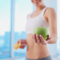 Uma mulher segurando uma maçã verde que uma das frutas de baixas calorias