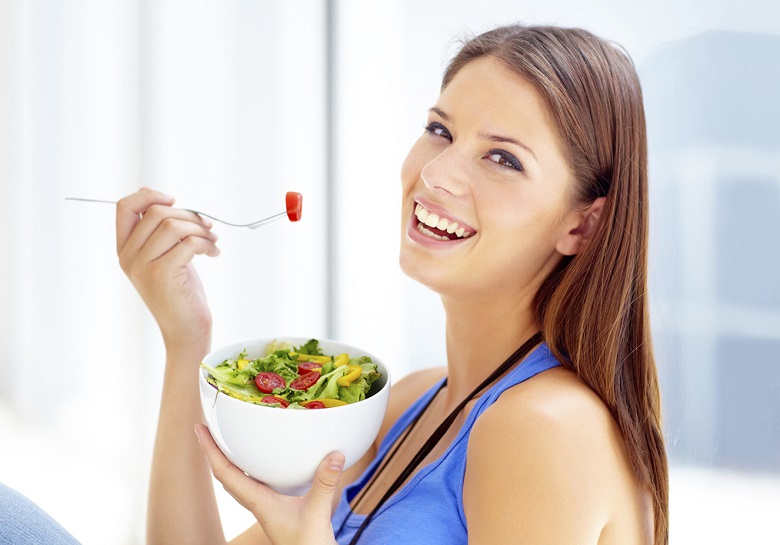 Uma mulher se alimentando corretamente praticando um dos hábitos saudáveis