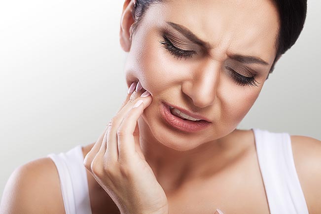 Uma mulher com dor de dente necessita de cuidados indispensáveis para a saúde bucal