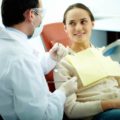 Odontólogo atendendo uma mulher com doenças bucais