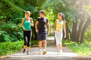 Três jovens praticando a caminhada que é dos 3 exercícios ao ar livre sugeridos