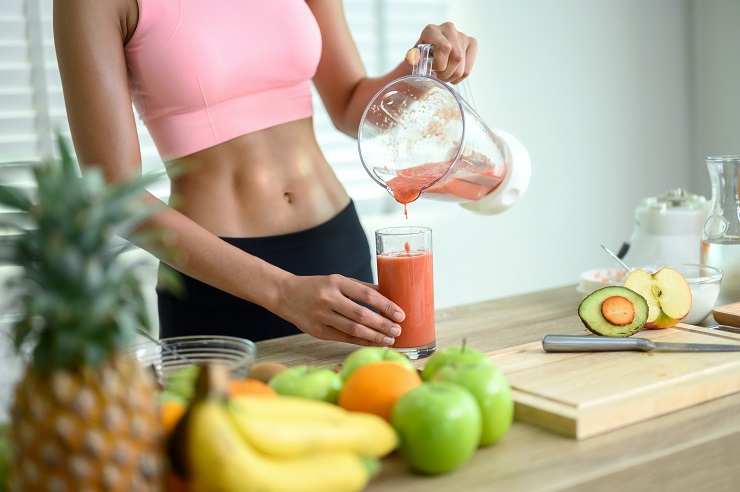 O equilíbrio para um emagrecimento saudável é importante. Uma mulher preparando uma vitamina saudável