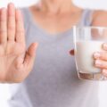 Uma mulher com copo de leite, lactose, na mão