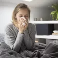 Uma mulher de cama com sintomas de gripe