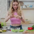 Uma mulher jovem preparando uma salada, uma maneira saudável, de como baixar o colesterol