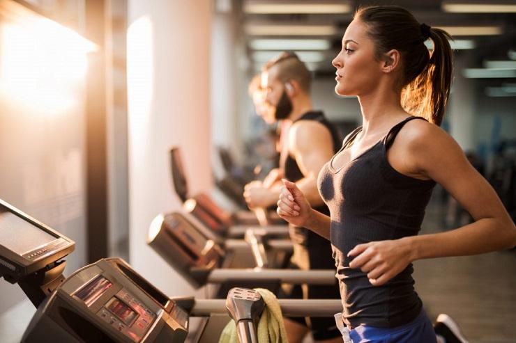 Uma mulher jovem fazendo cardio antes ou depois da musculação para ganhar músculos