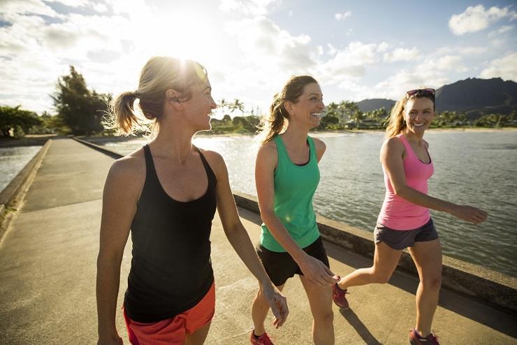 Um grupo de três mulheres comprovando os benefícios da caminhada para o corpo feminino